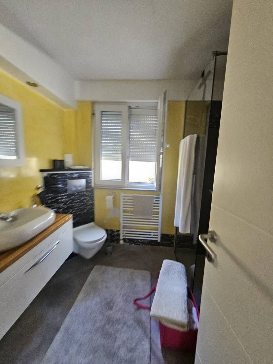Bathroom with wooden vanity unit and window