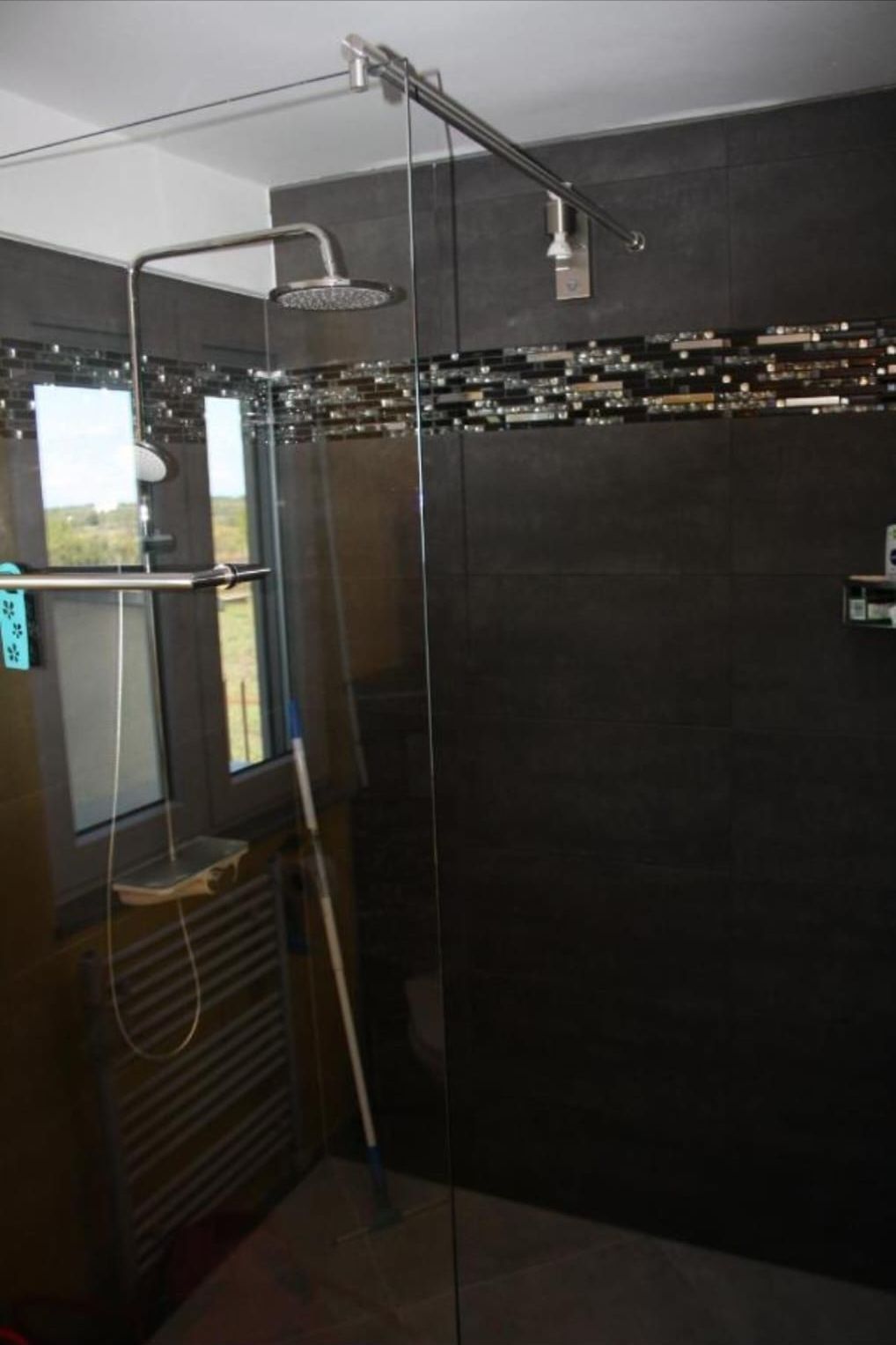 Walk-in rain shower with mosaic band and window