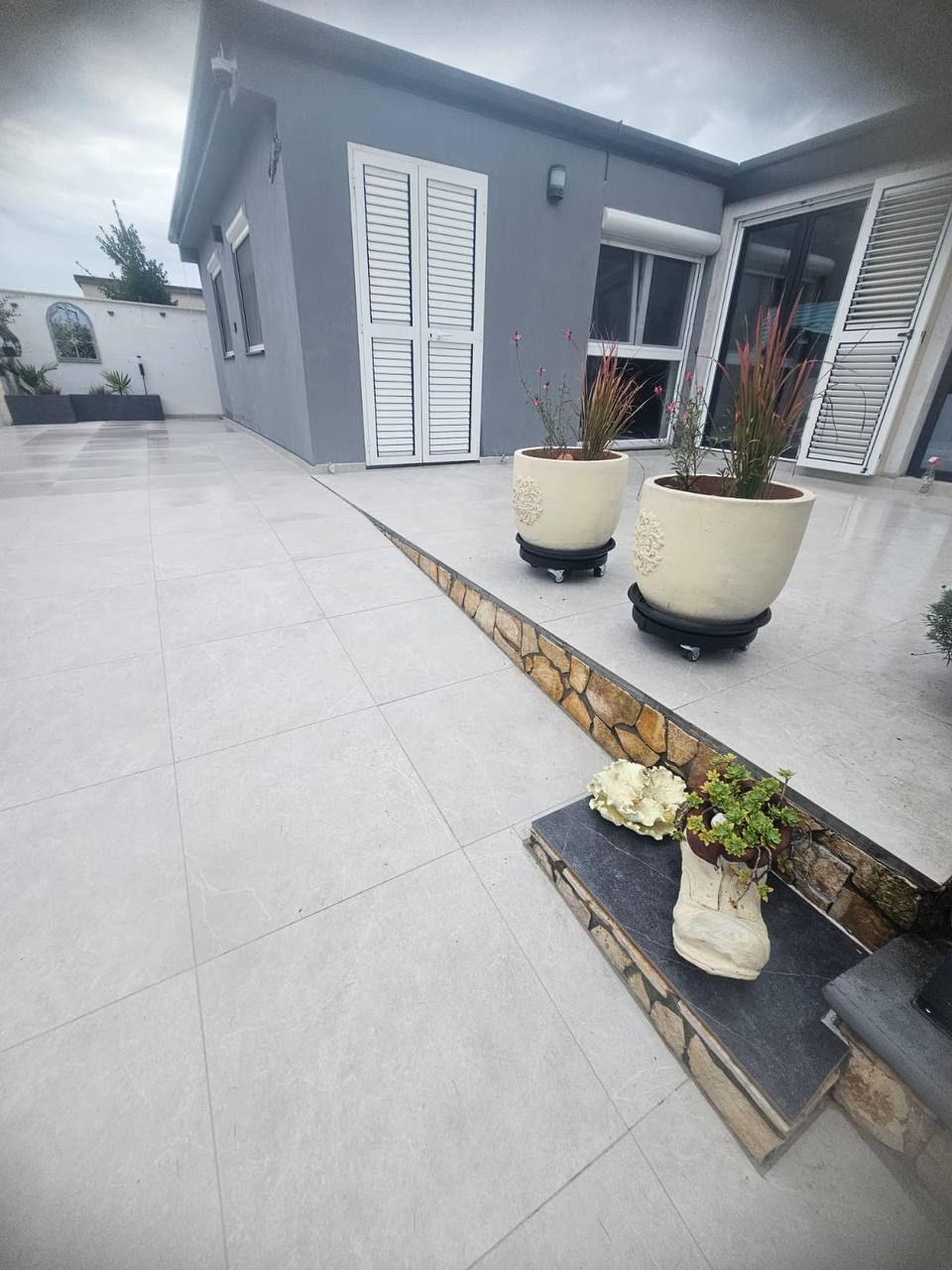 Entrance with planters and white shutters