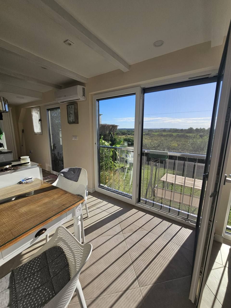 Dining table in front of the glass front with a view of the greenery