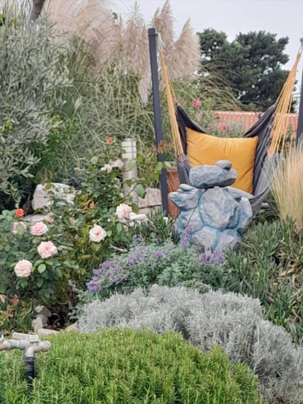 Hängesessel zwischen Rosen, Lavendel und Pampasgras